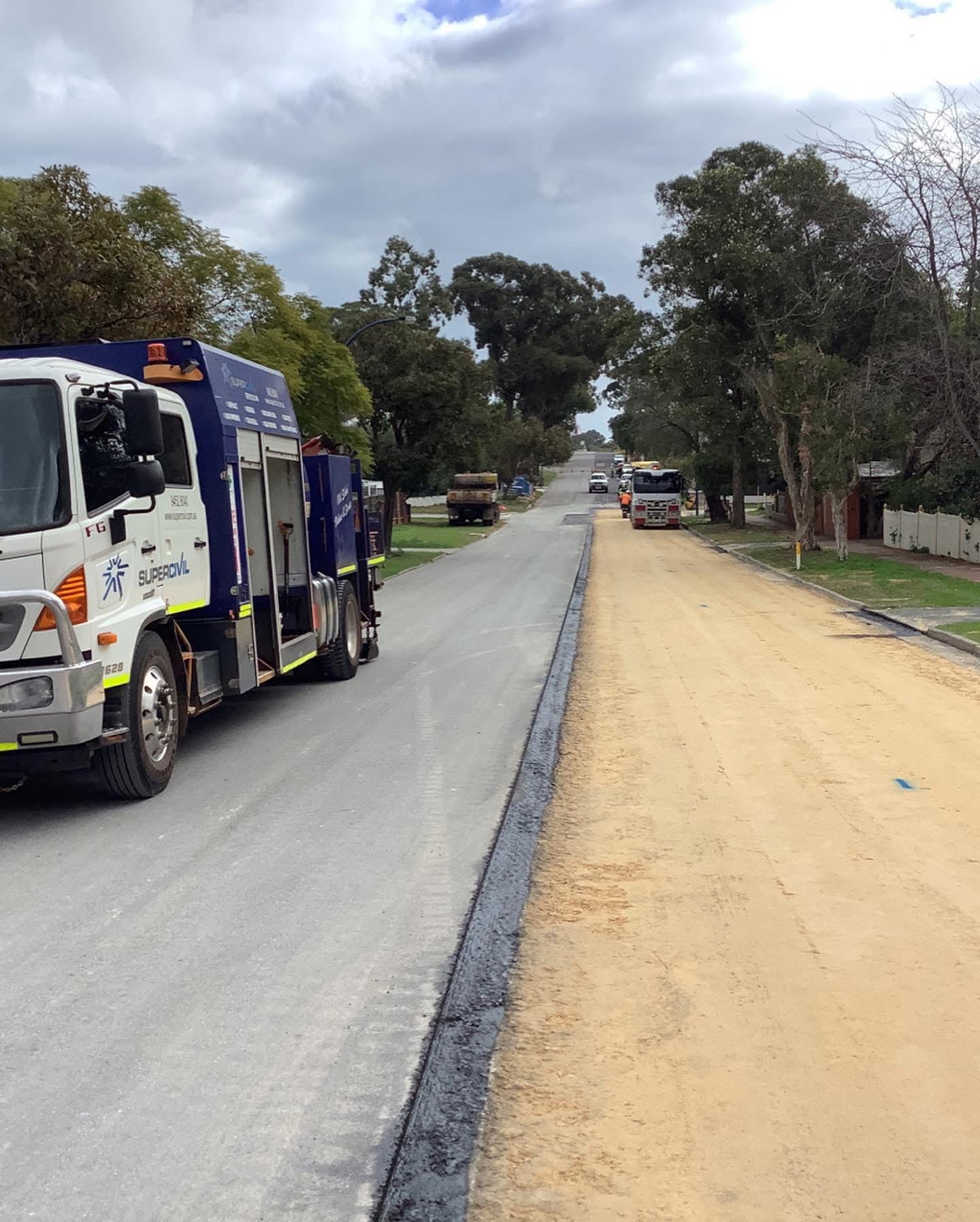 YongaCivil service truck parked on a suburban Perth street during road reconstruction, with one lane freshly sealed in new asphalt and the other stripped back to sand base