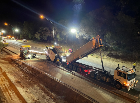 YongaCivil crew and asphalt paving machinery working under floodlights on a night-time Western Australian highway resurfacing project
