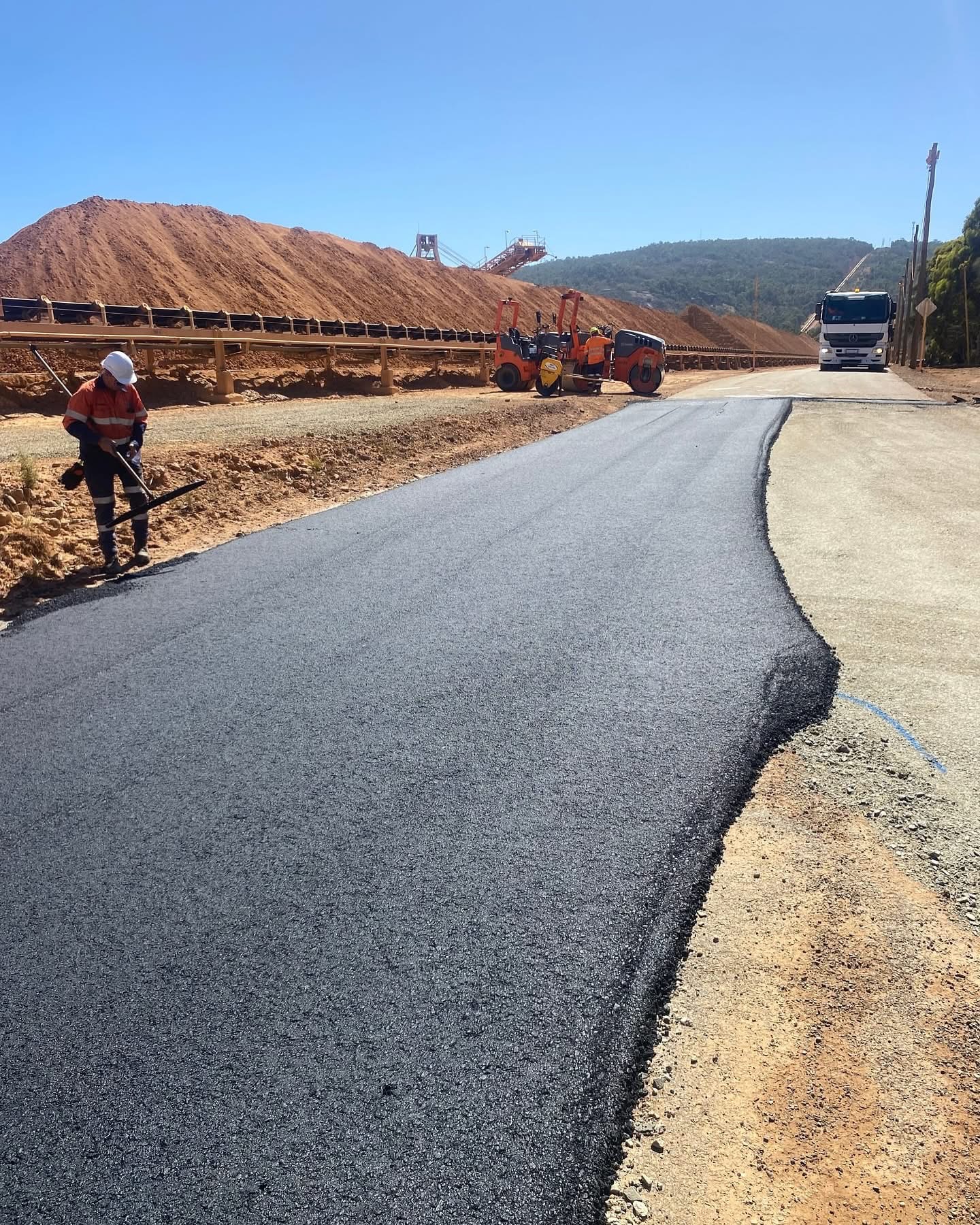 YongaCivil crew sealing a mine access road with rollers and stockpiles at a Western Australian resources site